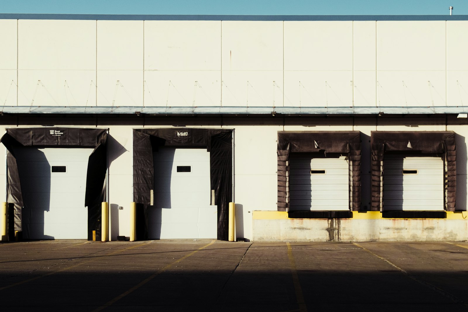 Loading dock bays with white roll-up doors and dock seals