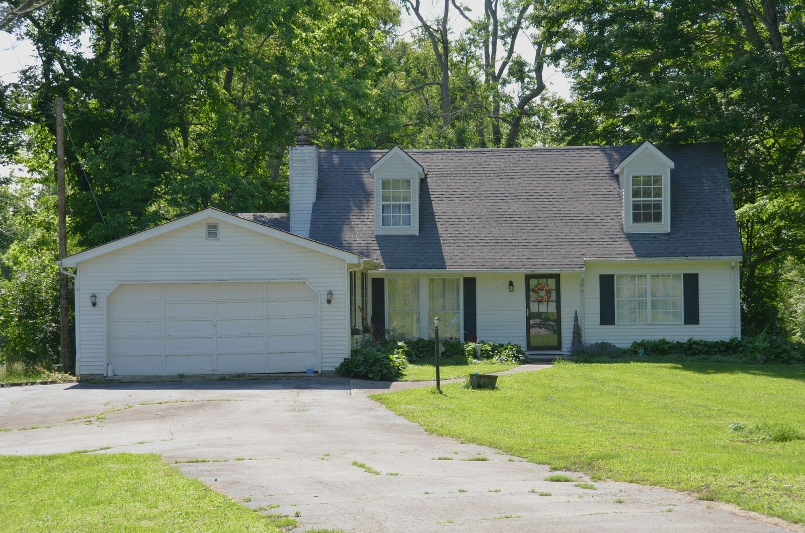 White two-car garage door beside a wide concrete driveway