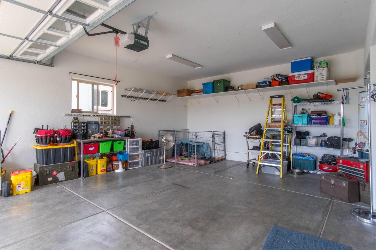 Organized home garage interior with ceiling-mounted door opener